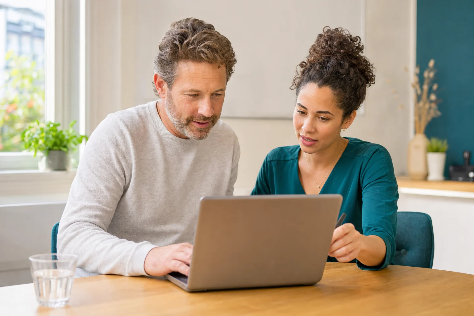 Een hulpvrager vult samen met een zorgcoördinator een aanvraag in op een laptop